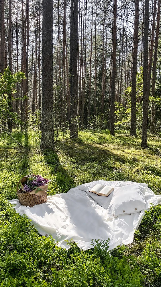 white linen bedding set in forest